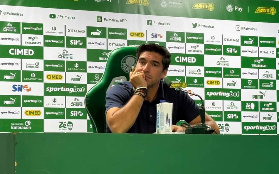 Abel Ferreira na sala de coletiva de imprensa sentado com expressão de pensativo