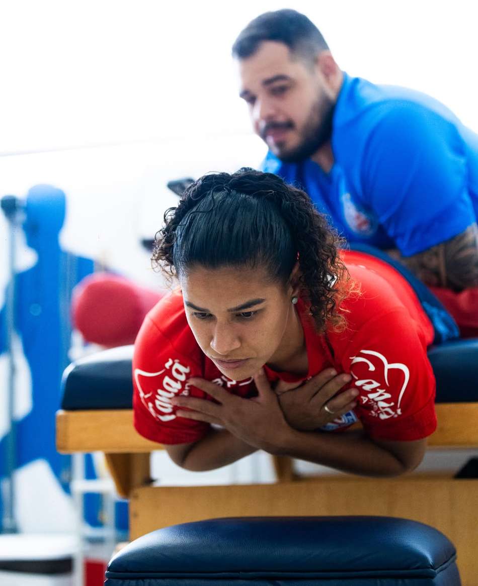Cássia, atacante do Bahia, deitada fazendo tratamento de massagem.