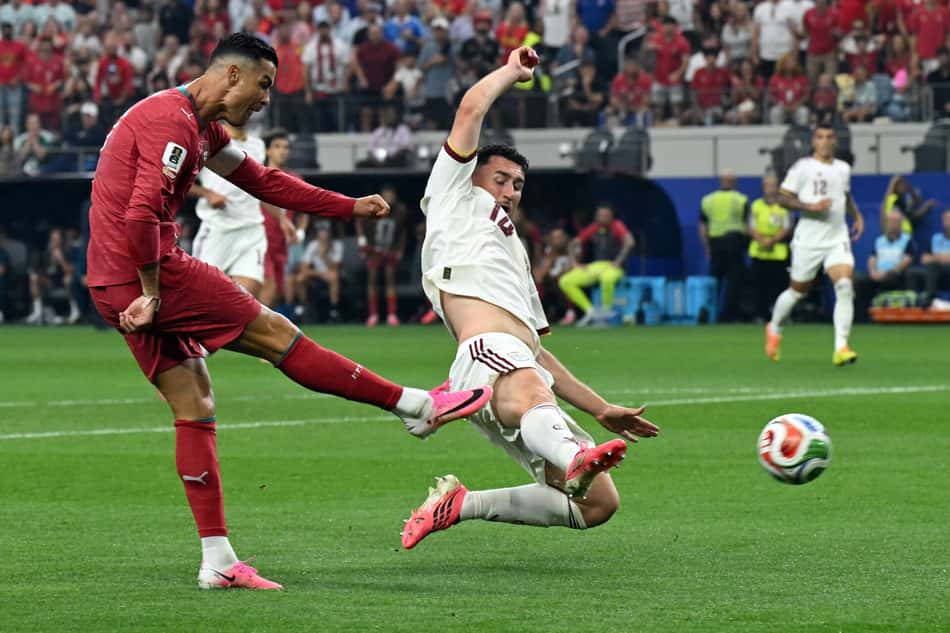 Cristiano Ronaldo chuta a bola passando pelo zagueiro espanhol Aymeric Laporte pela Copa do Mundo