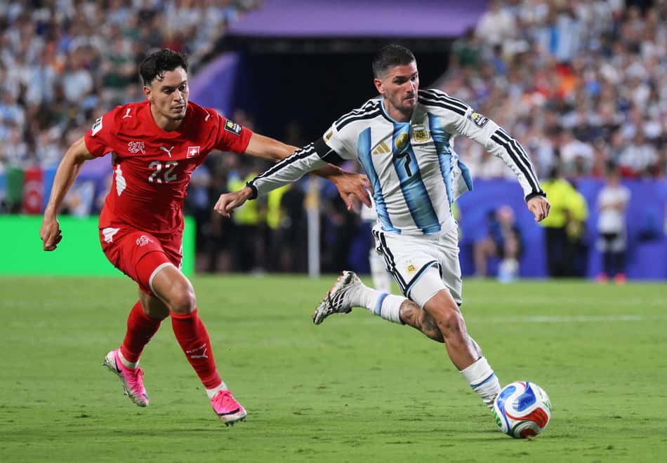 De Paul conduz a bola e é seguido por Rieder em Argentina x Suíça, na Copa do Mundo