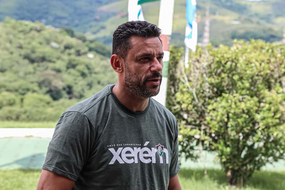 Anunciado como técnico do sub-20 do Fluminense, Fred olha para o lado de camisa cinza com a palavra "Xerém" e