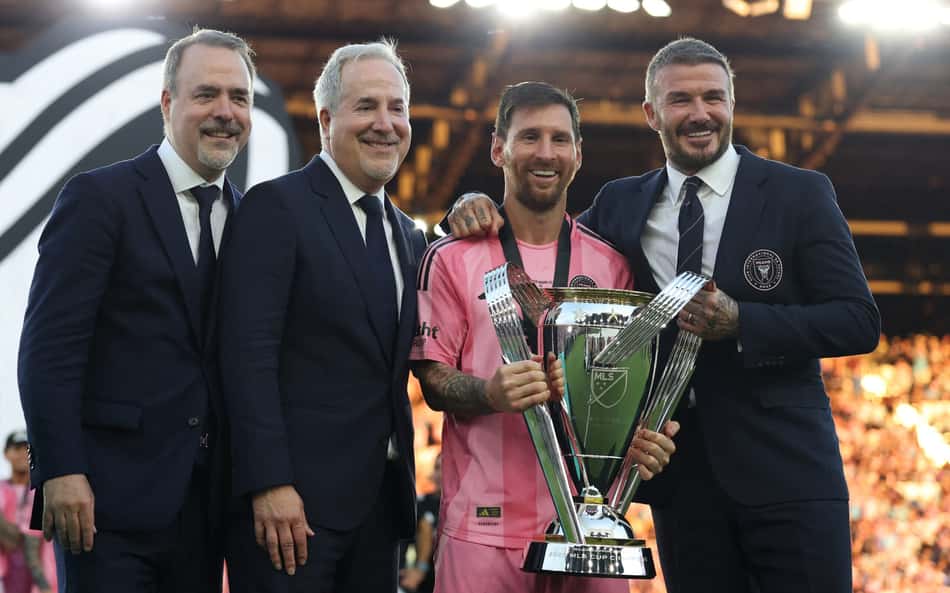 Lionel Messi com o troféu da MLS em mãos ao lado de Beckham e outros dois dirigentes