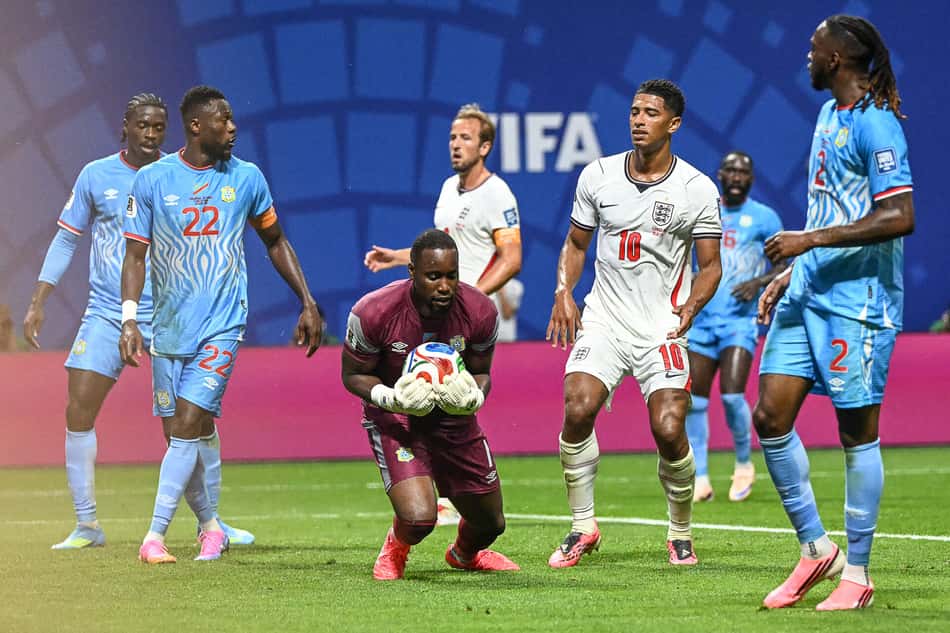 Lionel Mpasi, da RD Congo segurando a bola contra a Inglaterra na Copa do Mundo