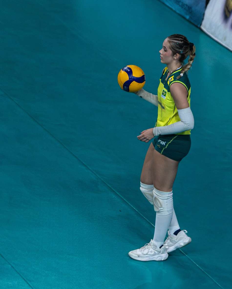 Segurando a bola com a mão direita, Mikaela se prepara para realizar saque em jogo da Seleção Brasileira sub-19