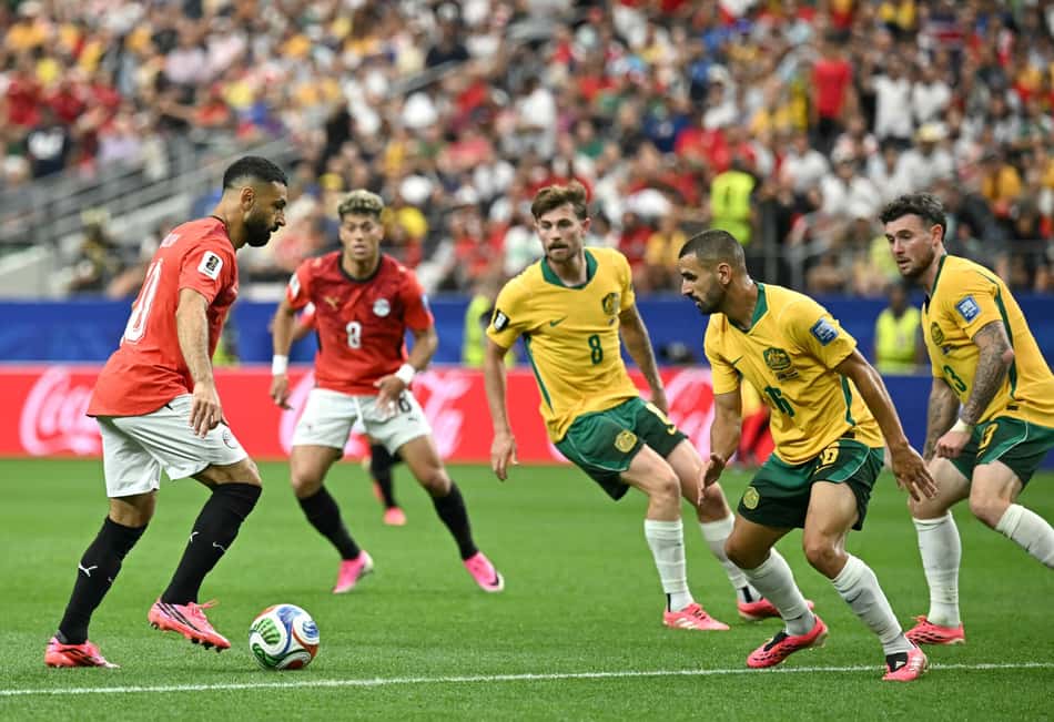 O atacante egípcio #10 Mohamed Salah (L) disputa a bola com o zagueiro australiano #16 Aziz Behich durante a partida dos 16 avos de final da Copa do Mundo de 2026 entre Austrália e Egito