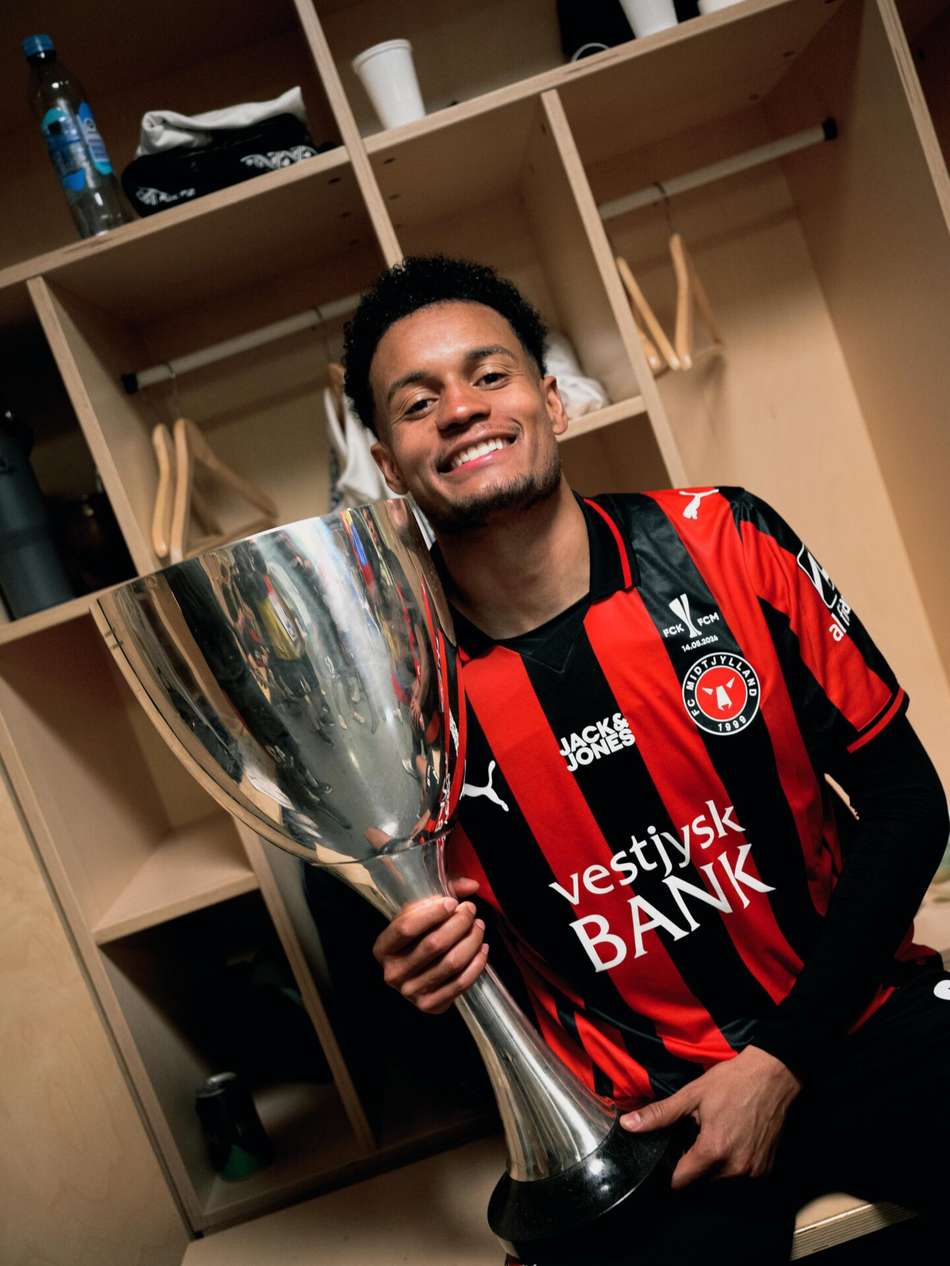 Paulinho, novo reforço do Botafogo, posando com troféu conquistado pelo Midtjylland