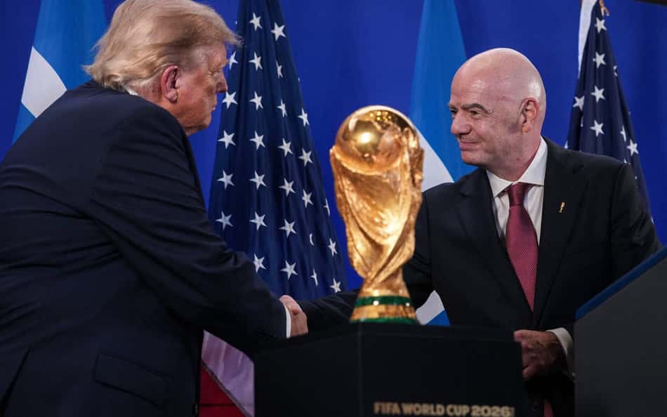 Trump e Infantino se cumprimetam ao lado do troféu da Copa do Mundo, que será erguido por Espanha ou Argentina