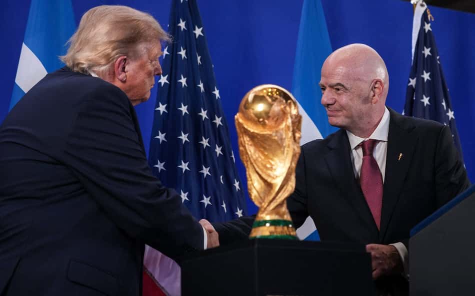 Trump e Infantino se cumprimetam ao lado do troféu da Copa do Mundo, que será erguido por Espanha ou Argentina
