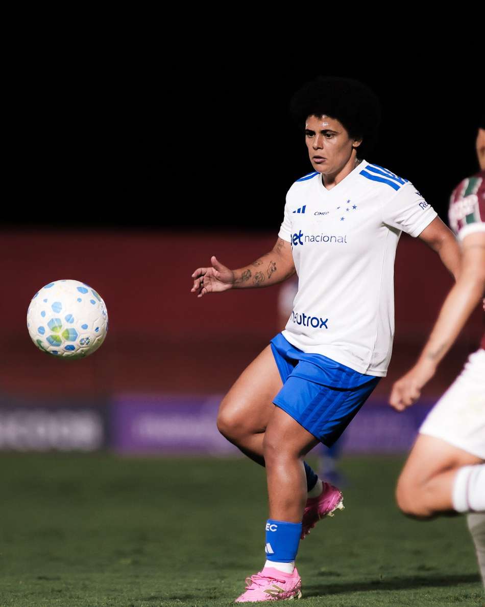 De uniforme branco com calção azul, Vanessinha domina a bola em jogo contra o Fluminense