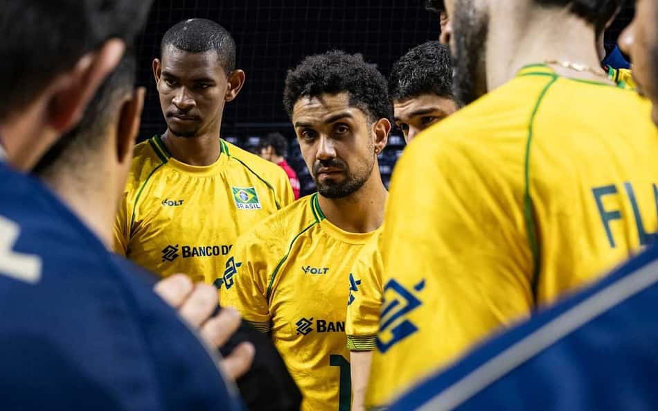 Jogadores da Seleção Brasileira durante tempo técnico, escutando membros da comissão, em jogo contra a China pela VNL; no centro, Fernando Cachopa aparece com um semblante sério