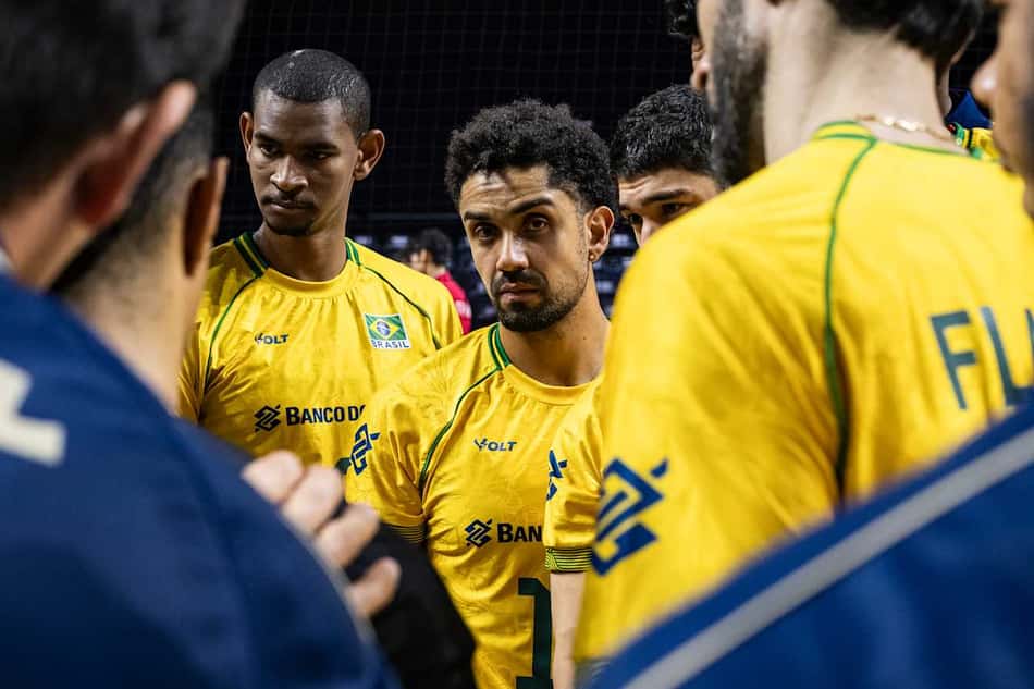 Jogadores da Seleção Brasileira durante tempo técnico, escutando membros da comissão, em jogo contra a China pela VNL; no centro, Fernando Cachopa aparece com um semblante sério