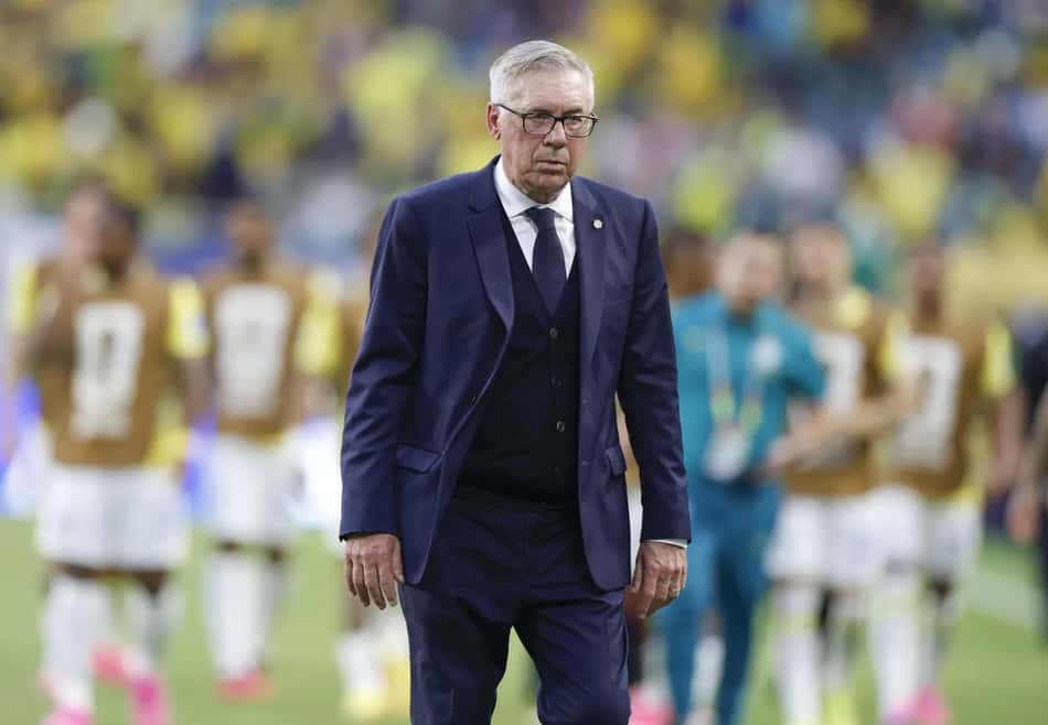 Carlo Ancelotti caminha no gramado de terno