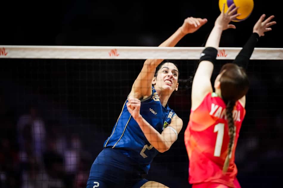 Com o uniforme azul, Diana ataca bola de meio contra jogadora japonesa, de vermelho