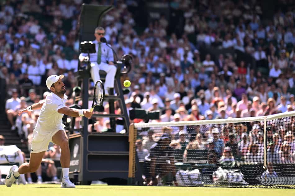De boné branco, Novak Djokovic aplica um forehand próximo à rede em jogo das oitavas de final de Wimbledon 2026