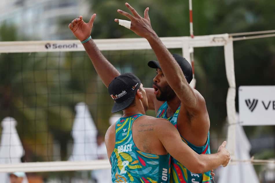Com os braços erguidos, Evandro recebe abraço de Arthur Lanci durante jogo do Circuito Mundial de vôlei de praia, no Rio de Janeiro