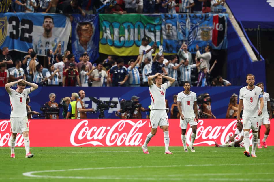 O zagueiro inglês número 15, Dan Burn, e seus companheiros de equipe lamentam o segundo gol da Argentina, marcado pelo atacante número 22, Lautaro Martínez (não visível na imagem), durante a partida semifinal da Copa do Mundo de 2026 entre Inglaterra e Argentina, no Estádio de Atlanta