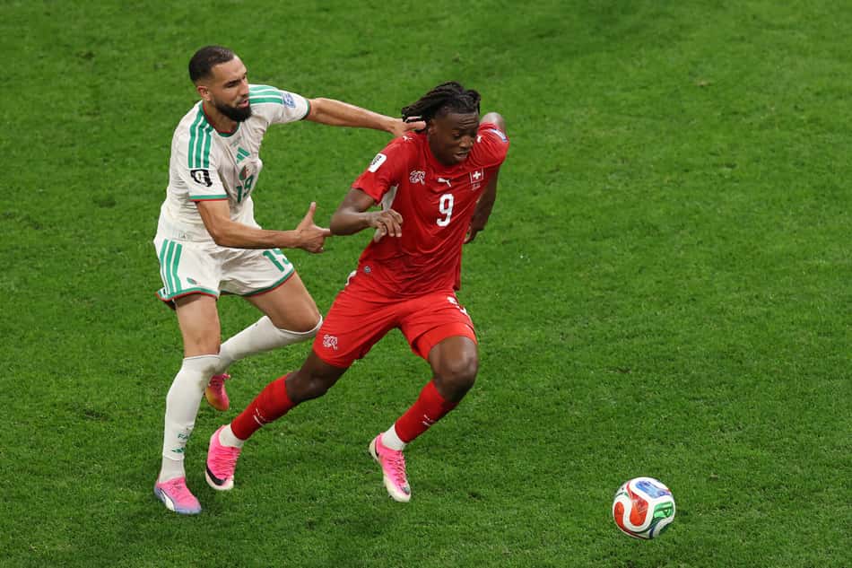 Johan Manzambi (nº 9), da Suíça, é disputado por Nabil Bentaleb (nº 19), da Argélia, durante a partida da fase de 32 da Copa do Mundo da FIFA 2026 entre Suíça e Argélia.