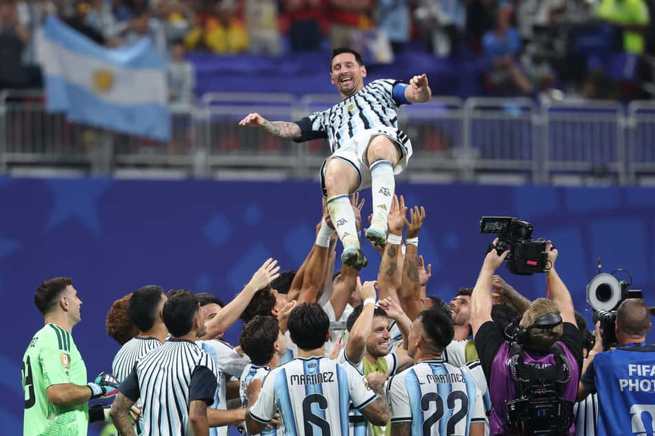 Messi sorridente é levantado por companheiros de time após vitória de virada da Argentina (Foto: Odd ANDERSEN / AFP)