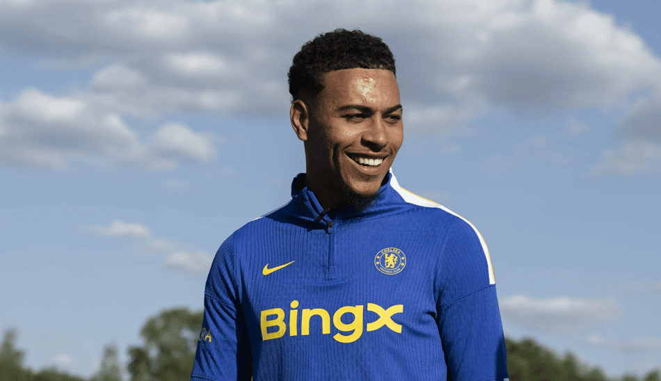 Morgan Rogers, novo jogador do Chelsea, sorri com o agasalho do clube de Londres