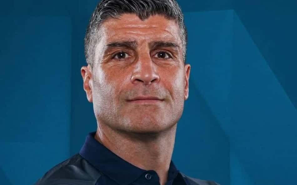 Pedro Emanuel com camisa azul escura com o corpo meio de lado