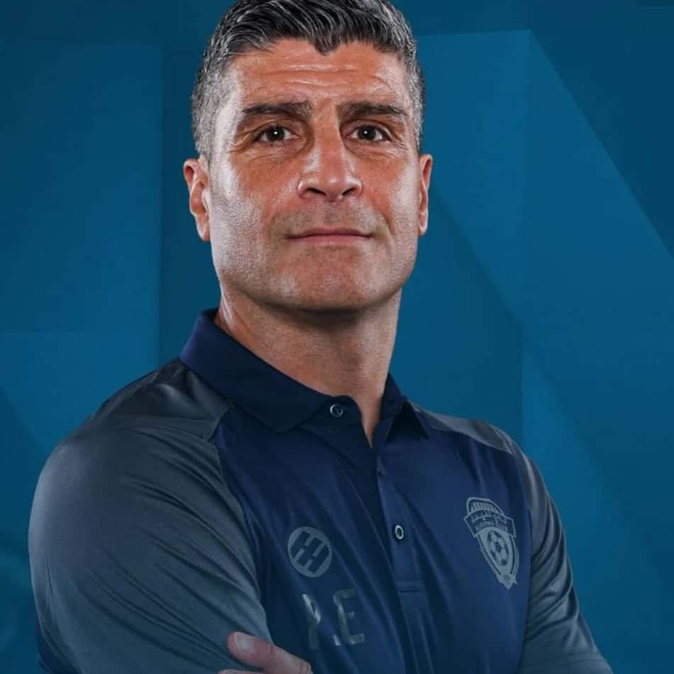 Pedro Emanuel com camisa azul escura com o corpo meio de lado