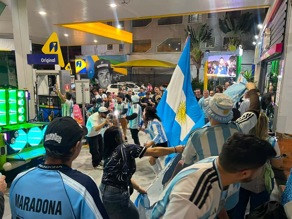 Torcedores com roupas e bandeiras da Argentina comemorando em São Paulo