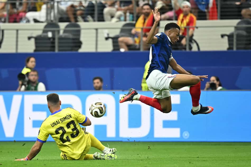 O atacante francês Kylian Mbappé salta sobre o goleiro espanhol Unai Simón em uma tentativa de marcar gol durante a semifinal entre França e Espanha, válida pelo torneio de futebol da Copa do Mundo de 2026.