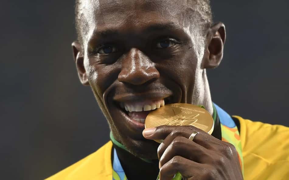 O jamaicano Usain Bolt morde a medalha de ouro conquistada nos Jogos Olímpicos Rio 2016