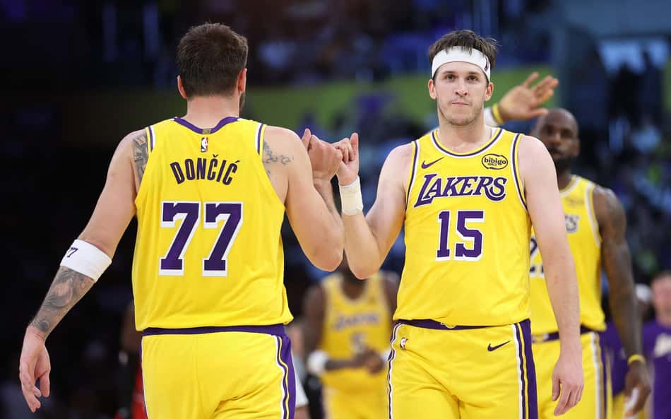 Luka Doncic e Austin Reaves, do Los Angeles Lakers, de mãos dadas durante tempo técnico contra o Chicago Bulls na Crypto.com Arena, em Los Angeles, em 12 de março de 2026 (Foto: Sean M. Haffey/Getty Images/AFP)