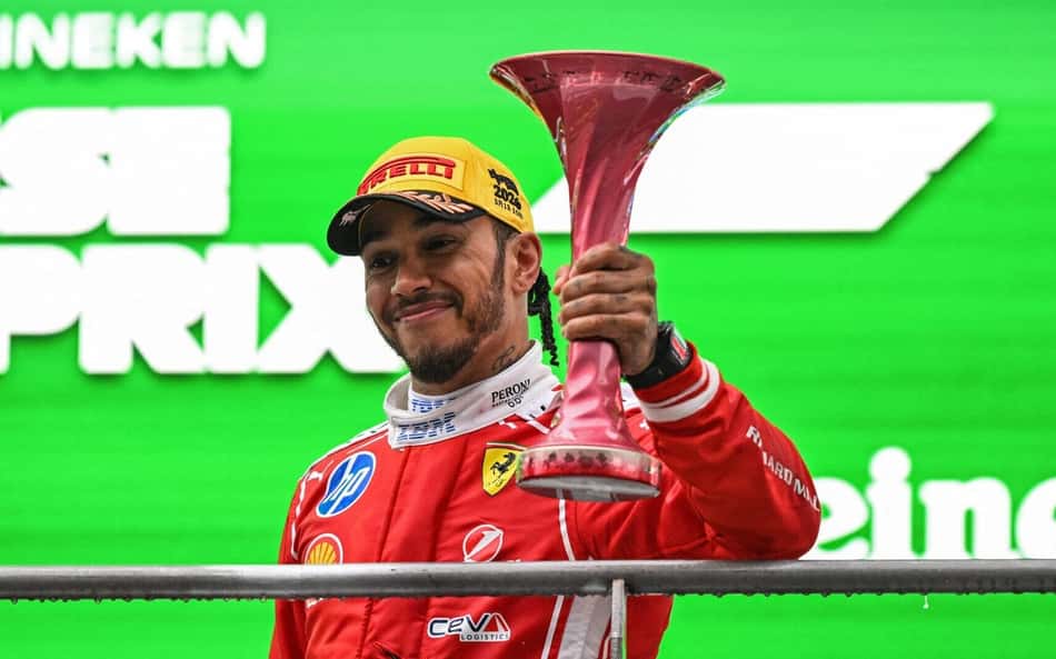 Lewis Hamilton celebra no pódio após terminar em terceiro lugar no GP da China de Fórmula 1, em 15 de março de 2026. (Foto: Greg Baker/AFP)