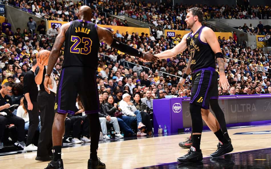 LeBron James (esquerda) e Luka Doncic (direita) se cumprimentam durante a partida do Lakers contra o Cleveland Cavaliers (Foto: Adam Pantozzi/ Getty Images via AFP)