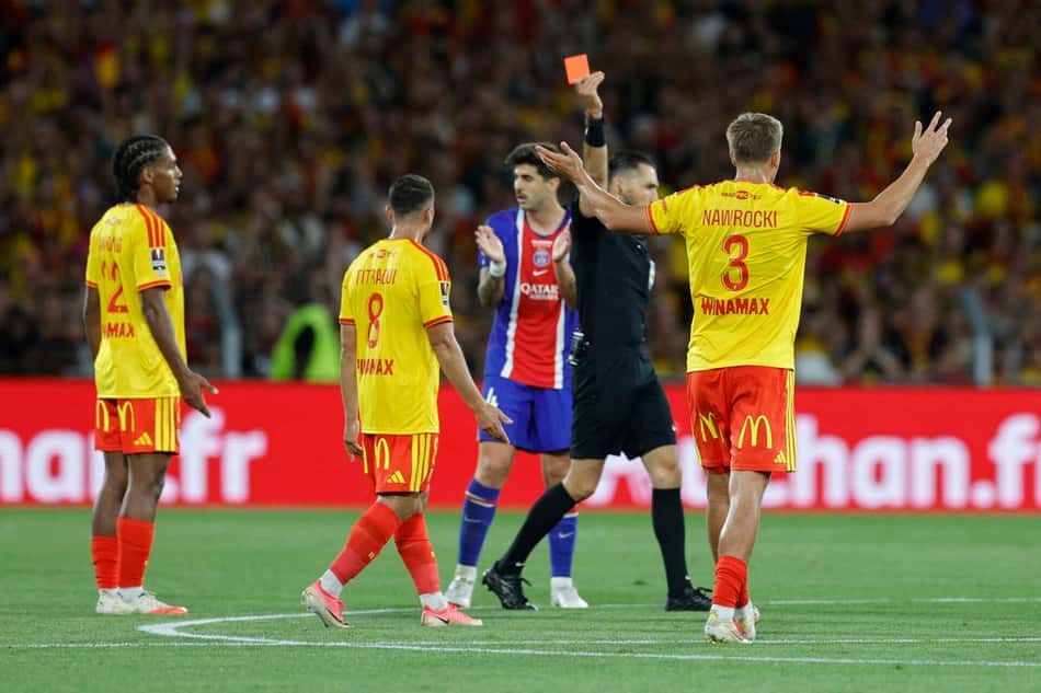 Árbitro segurando o cartão vermelho e jogadores do Lens em volta sinalizando uma revolta