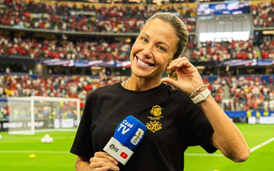 Bárbara Coelho com a camisa e microfone da CazéTV em estádio da Copa do Mundo