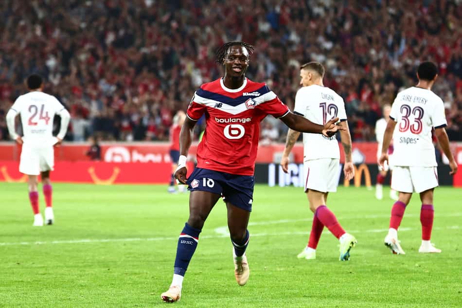 Bakwa comemorando gol com jogadores do PSG no fundo da imagem
