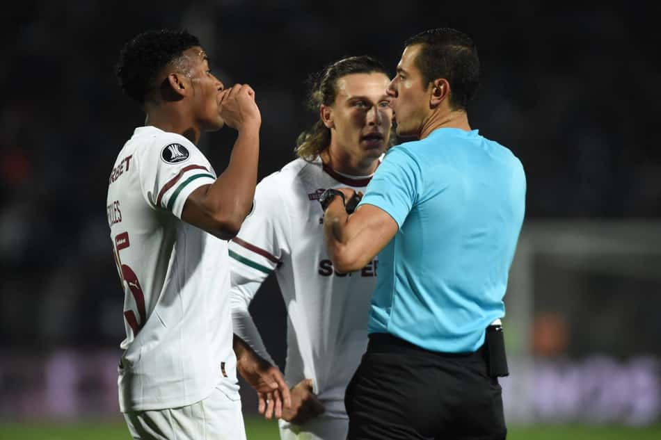 Agustín Canobbio, do Fluminense, coloca as mãos na cintura e encara o árbitro, que ergue o cartão vermelho em direção ao jogador, em duelo com o Independiente Rivadavia