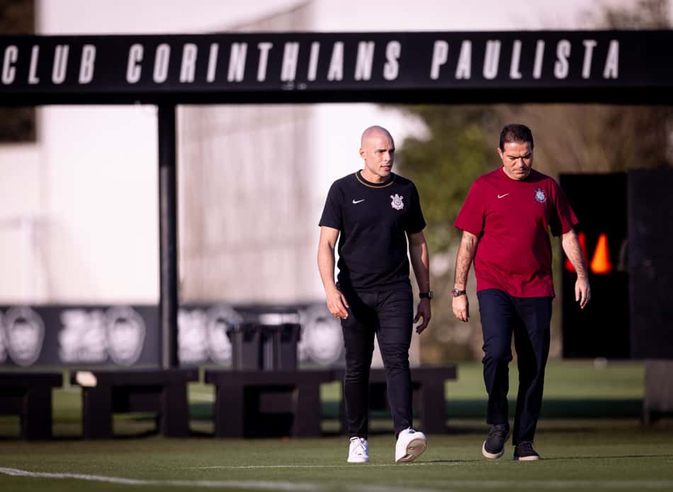 Julio Cesar e Marcelo Paz acompanham, lado a lado, a atividade do Corinthians no CT, observando o treino da equipe