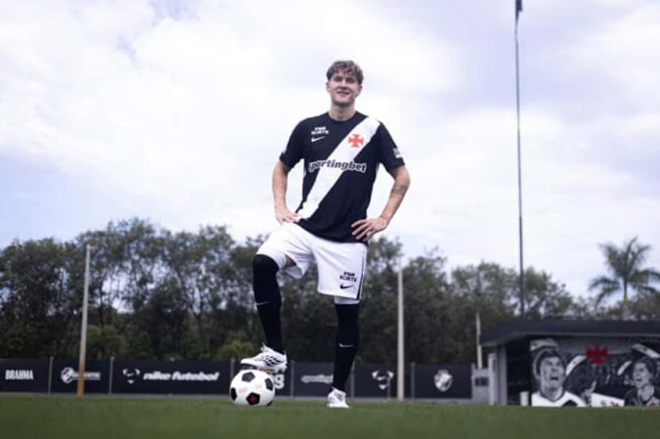 Facundo Colidio com uniforme do Vasco pisa na bola e sorri para a foto