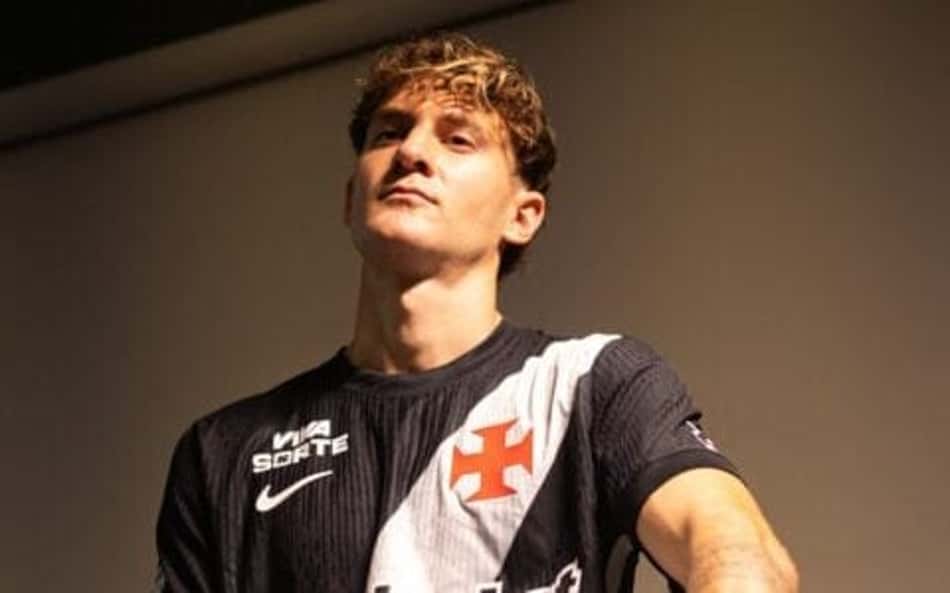 Facundo Colidio com camisa do Vasco sentado em um banco com a bola embaixo do braço