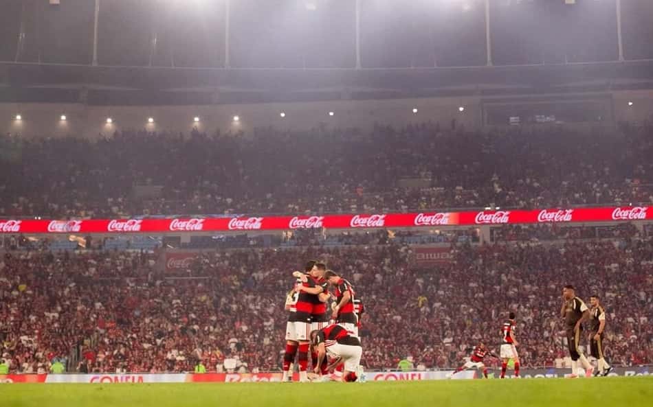 Jogadores do Flamengo se abraçando no gramado do Maracanã durante partida contra o Vitória pelo Brasileirão