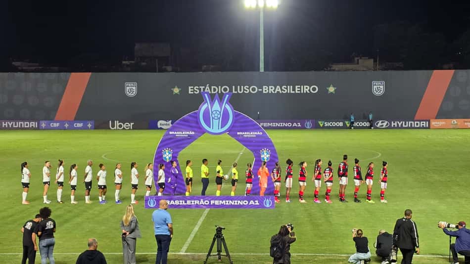 Equipes perfiladas no centro do gramado para o hino nacional