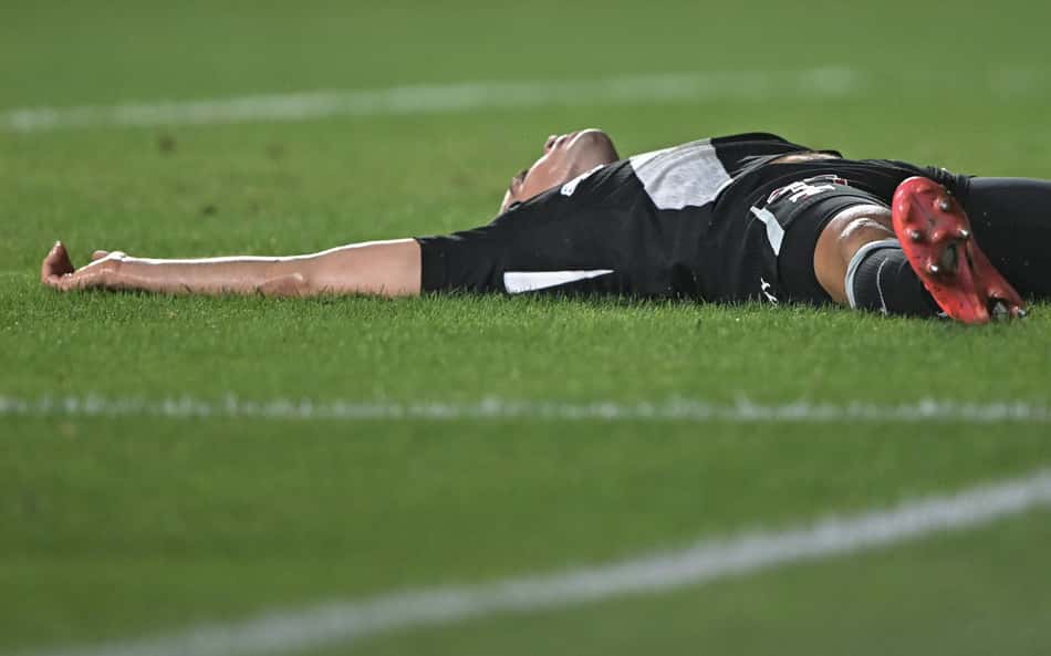 Jogador do Vasco deitado durante partida contra o Vitória