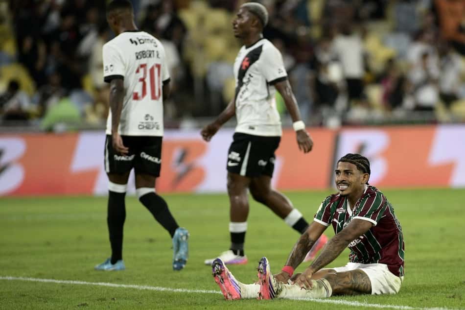John Kennedy, do Fluminense, sentado no gramado as mãos no joelho e expressão de dor em duelo contra o Vasco