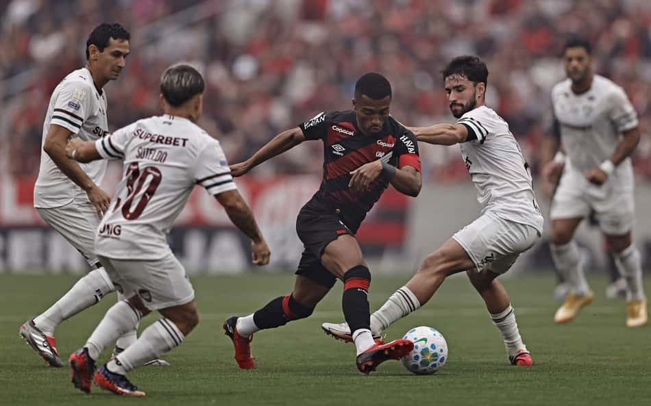 Leozinho do Athletico Paranaense disputa o lance com Paulo Henrique Ganso e Matheus Martinelli do Fluminense, durante a partida entre Athletico Paranaense e Fluminense
