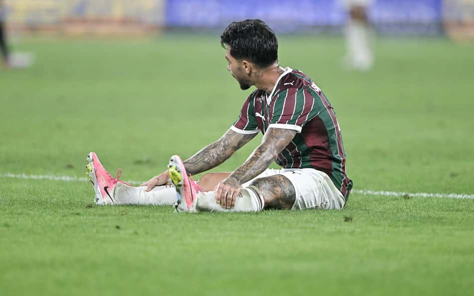 Lucho Acosta sentado no gramado durante duelo entre Fluminense e Vasco