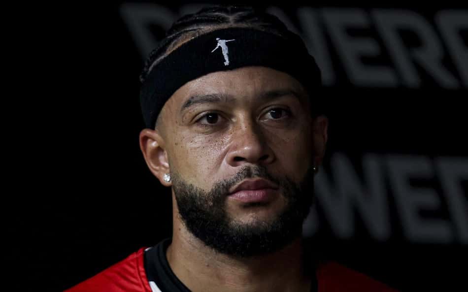 Memphis Depay no banco de reservas da Neo Química Arena com colete vermelho