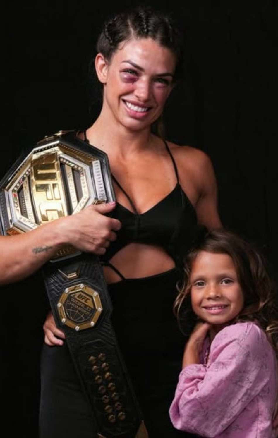 Mackenzie Dern com a filha, Moa, e o cinturão do UFC