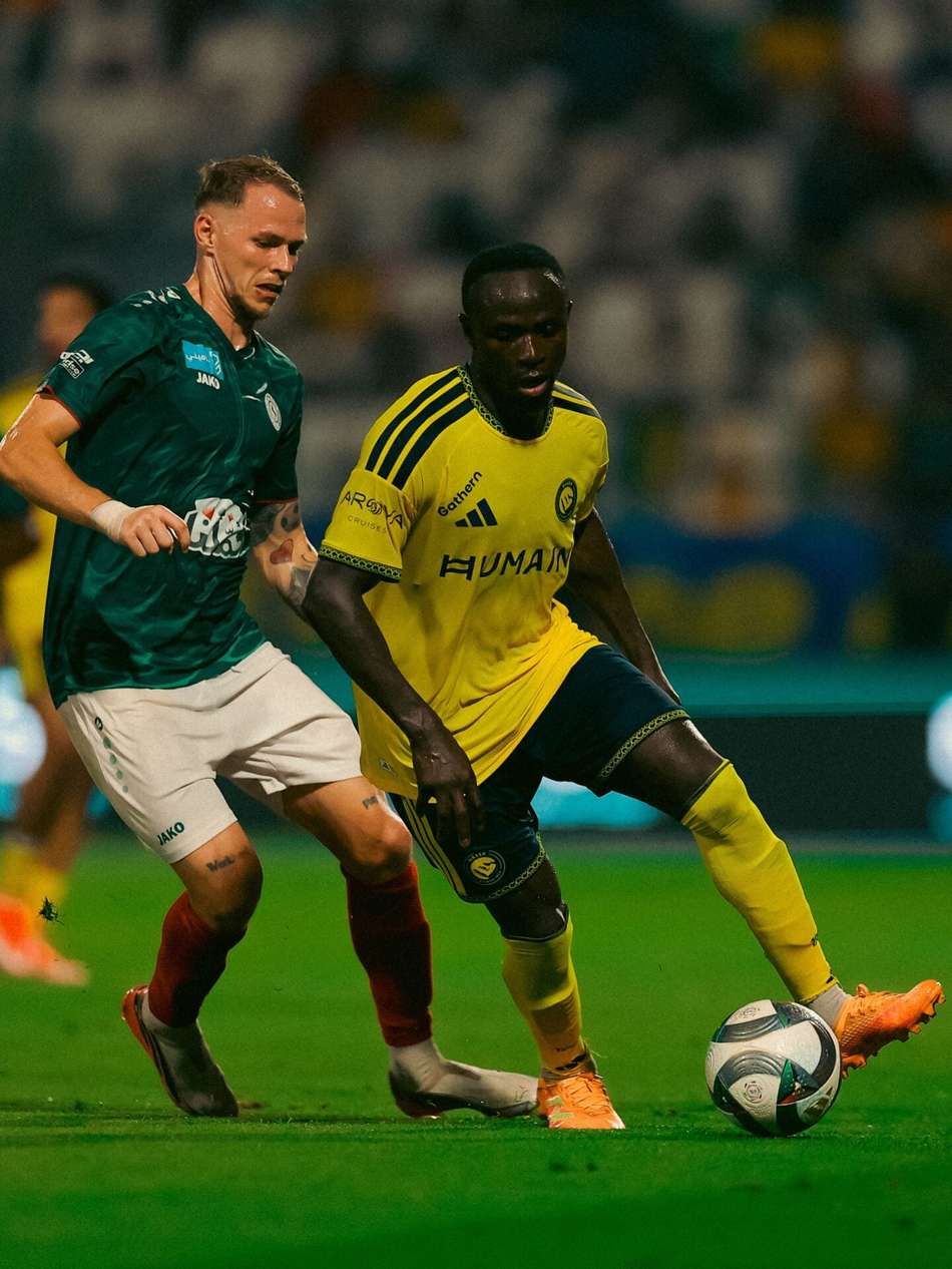 Mané driblhando adversário de camisa verde
