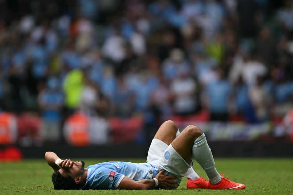 Marmoush caído no gramado no jogo entre Arsenal e Manchester City, pela Supercopa da Inglaterra