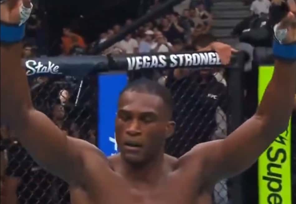 Michael PQD ergue os braços para comemorar a vitória na estreia no UFC