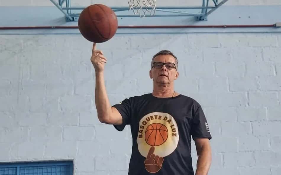 Miguel Ângelo da Luz, treinador de basquete vitorioso, com a camisa do seu projeto "Basquete da Luz"